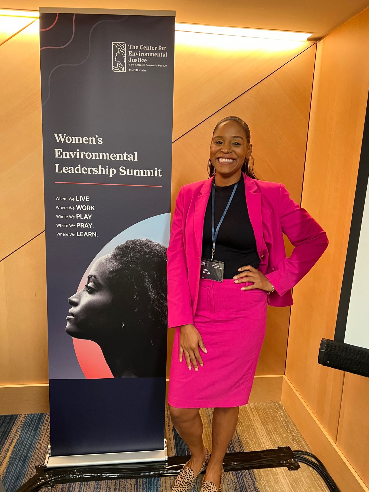 Jerri Taylor standing in front of the WEL summit banner