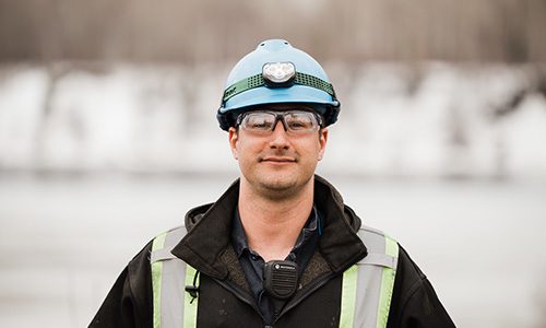 Young Indigenous man with hardhat and high visibility vest